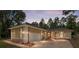 Charming single-story home showcasing stucco siding, an attached two-car garage, arched windows, and a brick driveway at 9180 Sw 202Nd Avenue Rd, Dunnellon, FL 34431