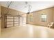 Spacious garage with a tan epoxy floor, cream walls, and windows with stained glass details at 9180 Sw 202Nd Avenue Rd, Dunnellon, FL 34431