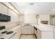 Open kitchen with white cabinets, stainless steel sink, and a view to the living room with fireplace at 9180 Sw 202Nd Avenue Rd, Dunnellon, FL 34431