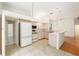 White kitchen with tile floors, and white appliances that opens to a dining area and living room at 9180 Sw 202Nd Avenue Rd, Dunnellon, FL 34431
