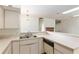 Kitchen with white countertops and cabinets, a stainless steel sink, and view of the living room fireplace at 9180 Sw 202Nd Avenue Rd, Dunnellon, FL 34431