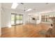 Bright and airy living room with wood floors, skylights, and a fireplace, with sliding doors to the pool area at 9180 Sw 202Nd Avenue Rd, Dunnellon, FL 34431