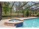 Screened pool area with a hot tub, brick pavers, and a serene wooded view at 9180 Sw 202Nd Avenue Rd, Dunnellon, FL 34431