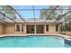 Screened pool with jacuzzi surrounded by brick, featuring a lush backdrop for ultimate outdoor relaxation at 9180 Sw 202Nd Avenue Rd, Dunnellon, FL 34431