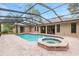 Gorgeous screened pool and spa area, surrounded by brick and lush foliage, perfect for relaxation at 9180 Sw 202Nd Avenue Rd, Dunnellon, FL 34431