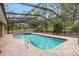 View of the screened-in pool with brick pavers and adjacent hot tub at 9180 Sw 202Nd Avenue Rd, Dunnellon, FL 34431