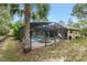 Screened in pool with attached spa, surrounded by brick pavers and tropical landscaping at 9180 Sw 202Nd Avenue Rd, Dunnellon, FL 34431