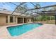 View of the screened pool and brick patio in the backyard of this home at 9180 Sw 202Nd Avenue Rd, Dunnellon, FL 34431