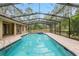 The screened pool area features brick pavers and a connected hot tub at 9180 Sw 202Nd Avenue Rd, Dunnellon, FL 34431