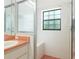 Tiled shower featuring a shower head, window, built in bench, and glass door at 9180 Sw 202Nd Avenue Rd, Dunnellon, FL 34431