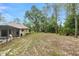 Expansive backyard with lush greenery, offering ample space and views of the home and pool area at 9180 Sw 202Nd Avenue Rd, Dunnellon, FL 34431