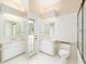 Bright bathroom with double sinks, white tile floor, a glass-enclosed shower, and a door to the outside at 9213 Sw 197Th Cir, Dunnellon, FL 34432