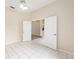 Bedroom featuring white tile flooring, a ceiling fan, and a view to another room through a doorway at 9213 Sw 197Th Cir, Dunnellon, FL 34432