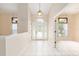 Bright foyer with white tile flooring, decorative chandelier, and sidelight windows on front door at 9213 Sw 197Th Cir, Dunnellon, FL 34432