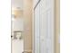 Hallway view featuring a double door closet and an adjacent doorway leading to a bathroom with white tiles at 9213 Sw 197Th Cir, Dunnellon, FL 34432