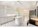 Spacious kitchen with white cabinets, island, stainless steel appliances, and ample lighting at 9213 Sw 197Th Cir, Dunnellon, FL 34432
