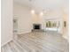 Bright living room features wood flooring, fireplace, vaulted ceilings, and sliding door to backyard at 9213 Sw 197Th Cir, Dunnellon, FL 34432