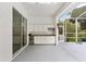 Covered patio featuring a fully equipped outdoor kitchen, screened enclosure and sliding doors to the home's interior at 9213 Sw 197Th Cir, Dunnellon, FL 34432