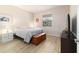 Bright bedroom with wood-look tile flooring, a wooden storage chest and a window view at 9236 Sw 91St Court Rd, Ocala, FL 34481