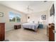 Comfortable bedroom with neutral walls, ceiling fan, and views of the well manicured lawn at 9236 Sw 91St Court Rd, Ocala, FL 34481