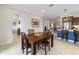 Dining room area showcasing a wooden dining table, seamlessly connected to the kitchen with modern countertops and an open floorplan at 9236 Sw 91St Court Rd, Ocala, FL 34481