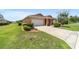 View of home featuring a two-car garage, manicured lawn, and colorful shrubs at 9236 Sw 91St Court Rd, Ocala, FL 34481