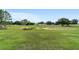 Spacious golf course view with lush green grass and mature trees on a sunny day at 9236 Sw 91St Court Rd, Ocala, FL 34481