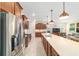 Spacious kitchen features stainless steel appliances, brown cabinetry, and a large center island at 9236 Sw 91St Court Rd, Ocala, FL 34481
