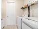 Bright laundry room featuring full size washer and dryer, and a utility storage shelf at 9236 Sw 91St Court Rd, Ocala, FL 34481