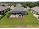 Aerial view of the house featuring a spacious backyard with a screened patio overlooking lush greenery at 9315 Sw 66Th Loop, Ocala, FL 34481