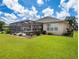 The lush backyard features a screened-in patio, with views of the serene lake and lush landscaping at 9315 Sw 66Th Loop, Ocala, FL 34481