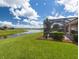 The lush backyard features a screened-in patio, with views of the serene lake and lush landscaping at 9315 Sw 66Th Loop, Ocala, FL 34481