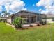 Enjoy a lush lawn and landscaped yard from the screened-in patio, complete with a hot tub at 9315 Sw 66Th Loop, Ocala, FL 34481