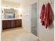 Bright bathroom with double sinks, a large mirror, and a view into a walk-in closet at 9315 Sw 66Th Loop, Ocala, FL 34481