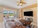 Living room with a comfortable leather sofa, patio access, and wall-mounted television at 9315 Sw 66Th Loop, Ocala, FL 34481