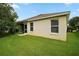 Well maintained backyard, lush green lawn, exterior of home, and screen room at 611 Allenwood Loop, The Villages, FL 32162