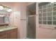 Bathroom featuring a glass block window, vanity with sink, and shower at 611 Allenwood Loop, The Villages, FL 32162