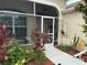Charming screened front porch with colorful landscaping and curb appeal at 611 Allenwood Loop, The Villages, FL 32162