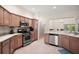Spacious kitchen features stainless steel appliances, tile flooring, and a breakfast bar overlooking an adjacent dining area at 611 Allenwood Loop, The Villages, FL 32162