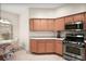 Bright kitchen features stainless steel appliances, wood cabinets, and an adjacent breakfast nook with views of the outdoors at 611 Allenwood Loop, The Villages, FL 32162