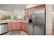 This kitchen features a stainless steel refrigerator, Corian countertops, and opens up to a dining area for easy entertaining at 611 Allenwood Loop, The Villages, FL 32162