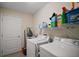 Well-equipped laundry room with washer, dryer, shelving, and ample storage space at 611 Allenwood Loop, The Villages, FL 32162