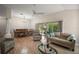 Bright living room featuring wood floors, a ceiling fan, and sliding glass doors at 611 Allenwood Loop, The Villages, FL 32162