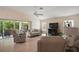Bright living room with vaulted ceilings, sliding glass doors to the lanai, and comfortable seating arrangement at 611 Allenwood Loop, The Villages, FL 32162