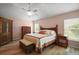 Cozy main bedroom with wood floors, ceiling fan, and natural light at 611 Allenwood Loop, The Villages, FL 32162