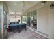 Relaxing screened-in porch with tile floor and comfortable wicker furniture at 611 Allenwood Loop, The Villages, FL 32162