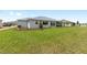 Green grass backyard featuring a home with a gray roof and mulched plant beds at 10032 Sw 85Th Place Rd, Ocala, FL 34481