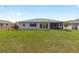 A spacious backyard features green grass and is accented with small trees and mulched plant beds at 10032 Sw 85Th Place Rd, Ocala, FL 34481