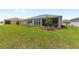 Green backyard featuring a covered patio, small trees, and an attractive landscape design at 10032 Sw 85Th Place Rd, Ocala, FL 34481