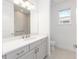 Bathroom featuring gray vanity, quartz countertop, square mirror, and white tiling at 10032 Sw 85Th Place Rd, Ocala, FL 34481